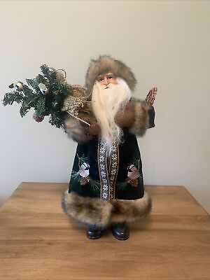 #ad 15” Santa Claus In a green jacket aligned with fur carrying a tree and snowshoes $27.00